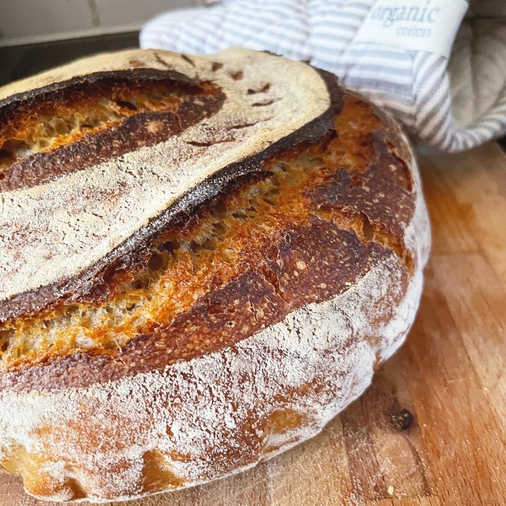 Nygräddad surdegslimpa på skärbräda.